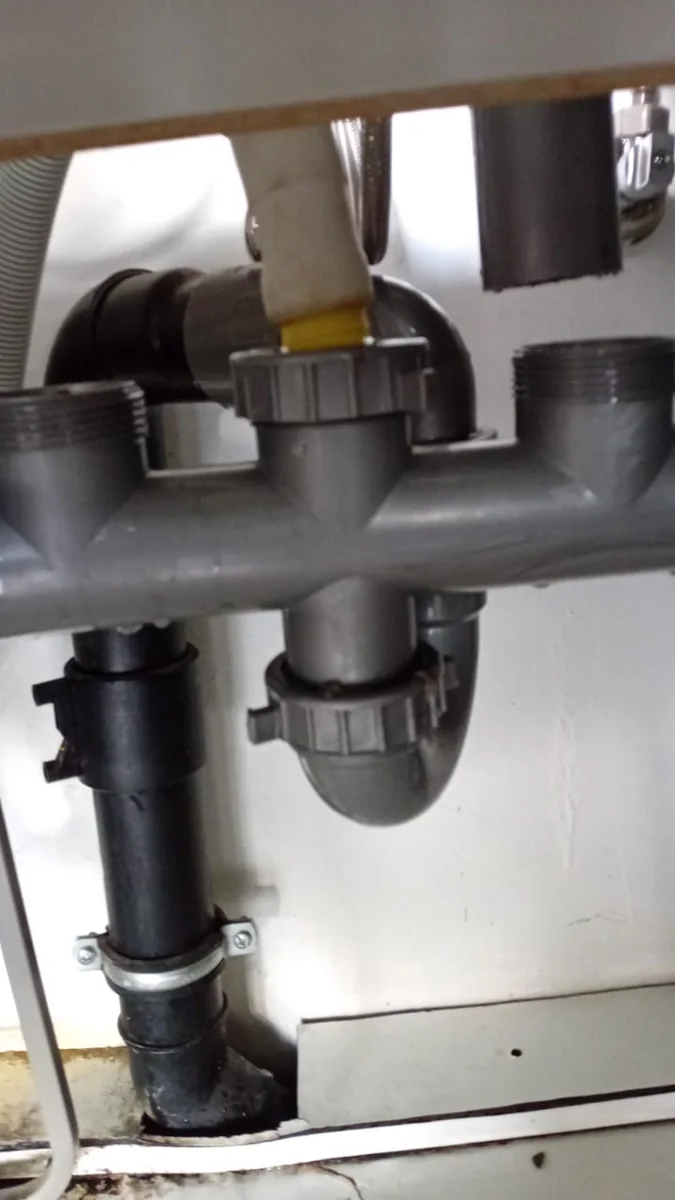 Combination waste trap replaced under a basin after a DIY repair attempt in Bordeaux.