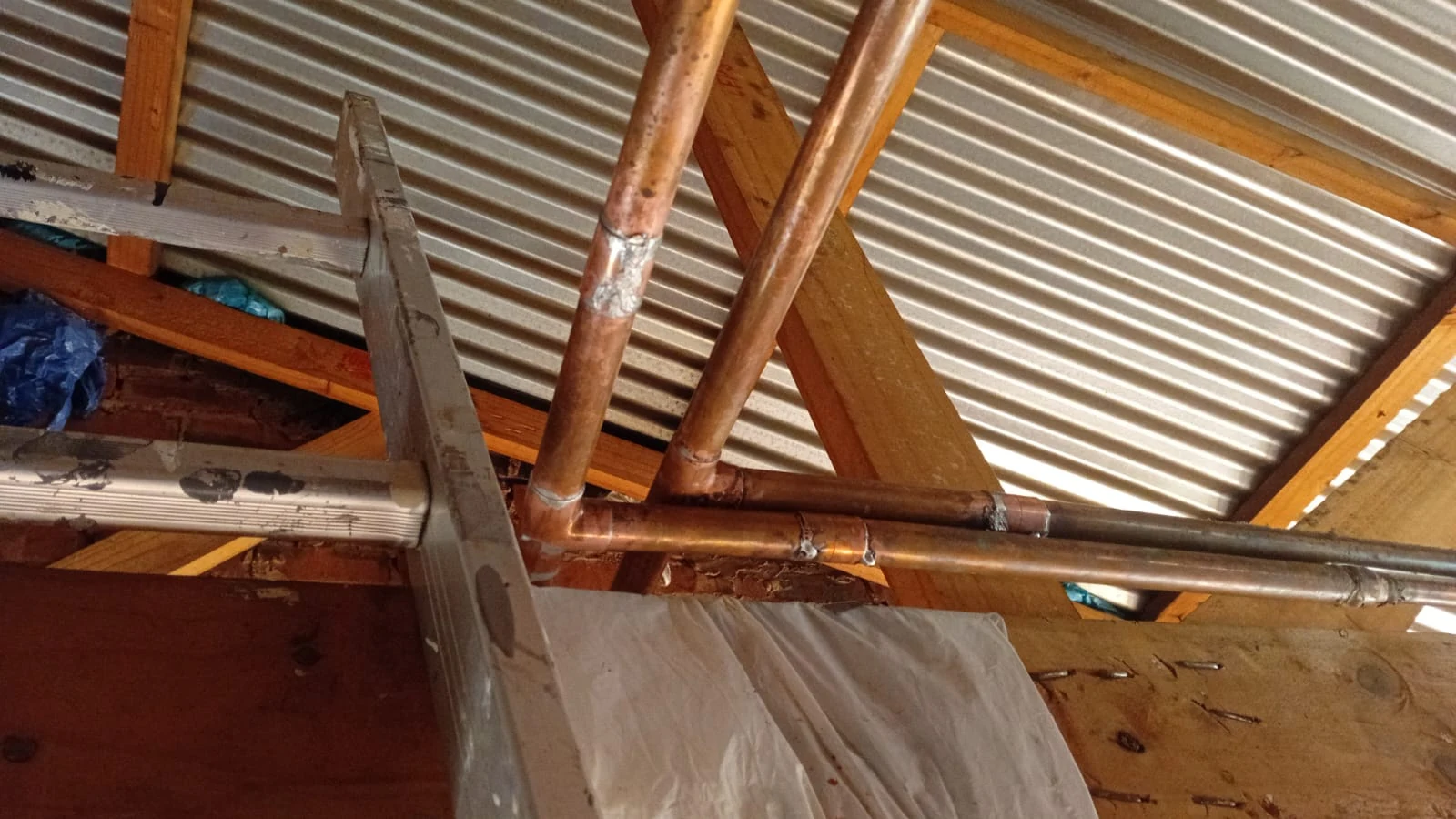 Burst pipe repair work on copper pipework inside a roof space.