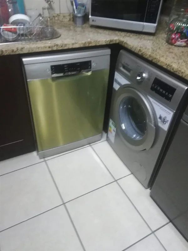 Dishwasher and washing machine installed beside a kitchen sink during a Randburg appliance plumbing job.