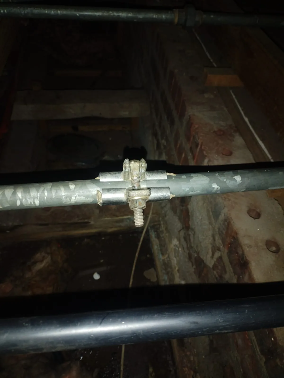 Emergency clamp fitted to a burst galvanised pipe in Ferndale before full pipe replacement.